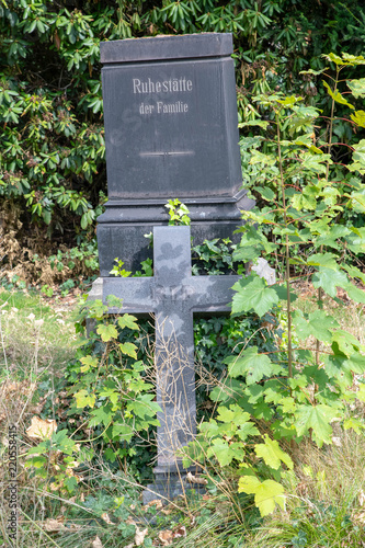 Fototapet Alter Grabstein von dem das Kreuz herunter gefallen ist