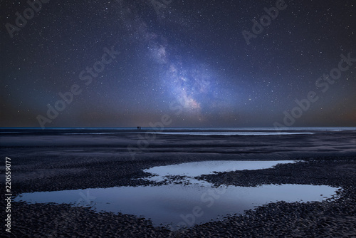 Vibrant Milky Way composite image over landscape of beach at low tide photo