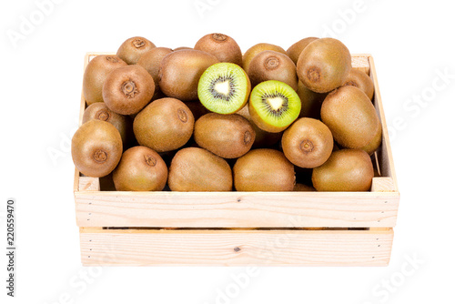 Wooden box filled with many ripe and fresh kiwi fruits and two half fruits isolated on white background