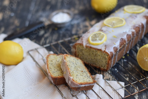 Lemon cake with poppy seeds with sugar icing on a brown wooden background