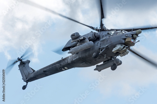 Military helicopter in the sky on a combat mission with weapons.