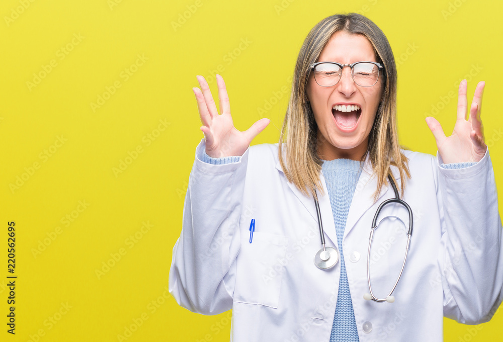 Young beautiful doctor woman headphones over isolated background celebrating mad and crazy for success with arms raised and closed eyes screaming excited. Winner concept Young beautiful doctor woman headphones over isolated background celebrating mad and crazy for success with arms raised and closed eyes screaming excited. Winner concept