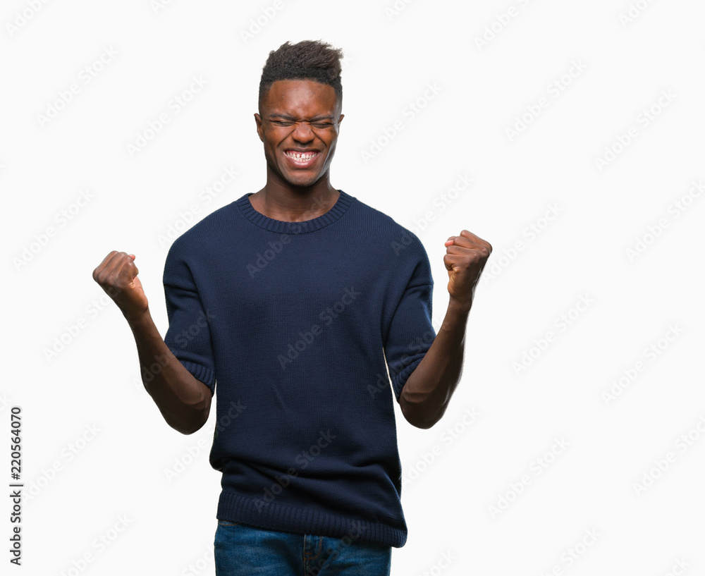 Young african american man over isolated background celebrating surprised and amazed for success with arms raised and open eyes. Winner concept. Young african american man over isolated background celebrating surprised and amazed for success with arms raised and open eyes. Winner concept.