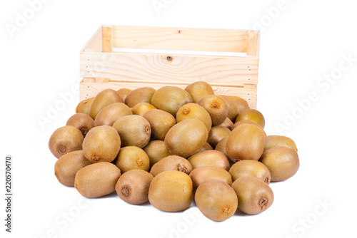 Empty wooden box and in the front of it a many fresh ripe whole kiwi fruits isolated on white background
