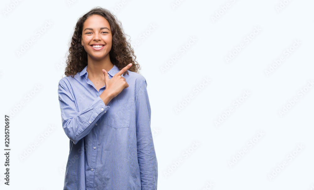 Young hispanic business woman cheerful with a smile of face pointing with hand and finger up to the side with happy and natural expression on face looking at the camera. Young hispanic business woman cheerful with a smile of face pointing with hand and finger up to the side with happy and natural expression on face looking at the camera.