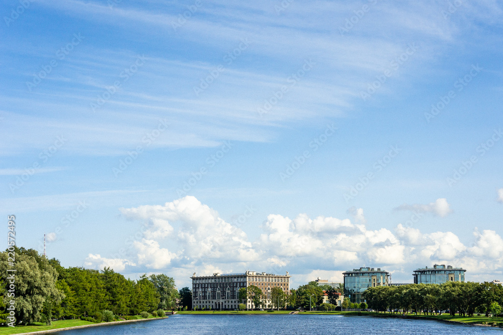 Houses in the river valley. Blue sky with clouds