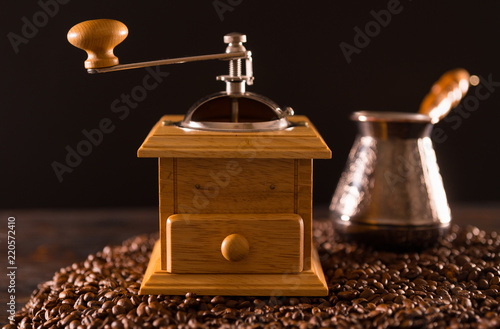 Wooden coffee grinder sitting on coffee beans