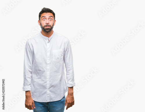 Adult hispanic man over isolated background puffing cheeks with funny face. Mouth inflated with air, crazy expression.