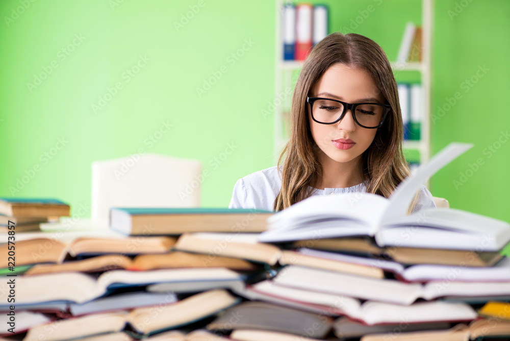 Young female student preparing for exams with many books Young female student preparing for exams with many books