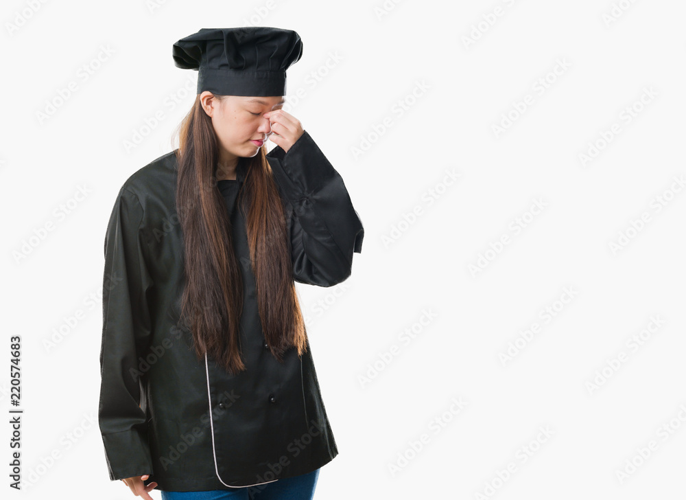 Young Chinese woman over isolated background wearing chef uniform tired rubbing nose and eyes feeling fatigue and headache. Stress and frustration concept. Young Chinese woman over isolated background wearing chef uniform tired rubbing nose and eyes feeling fatigue and headache. Stress and frustration concept.