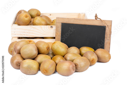 Wooden box filled with many ripe kiwi fruits and a old blank slate blackboard isolated on white background