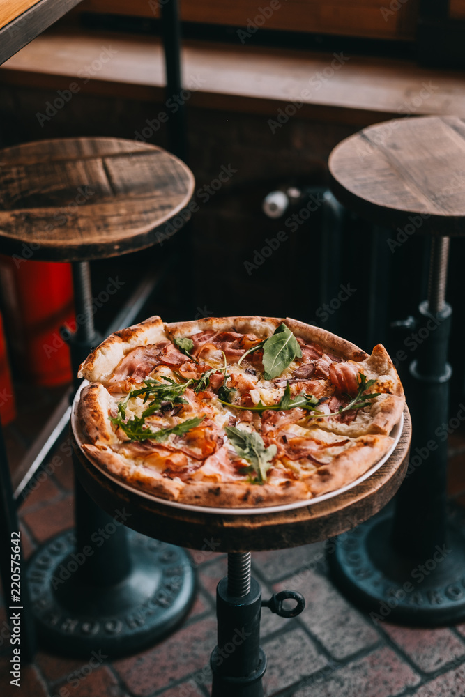 Pizza carbonara on rustic wooden table at the restaurant. Food photography concept. Copyspace