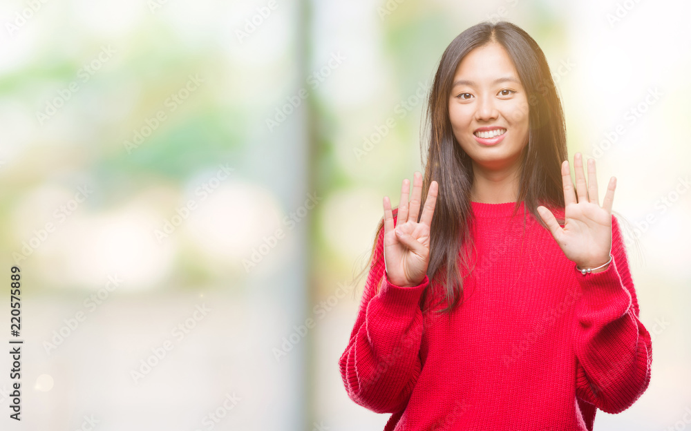 Young asian woman wearing winter sweater over isolated background showing and pointing up with fingers number nine while smiling confident and happy.
