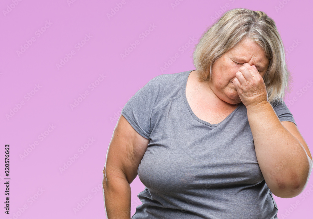 Senior plus size caucasian woman over isolated background tired rubbing nose and eyes feeling fatigue and headache. Stress and frustration concept. Senior plus size caucasian woman over isolated background tired rubbing nose and eyes feeling fatigue and headache. Stress and frustration concept.