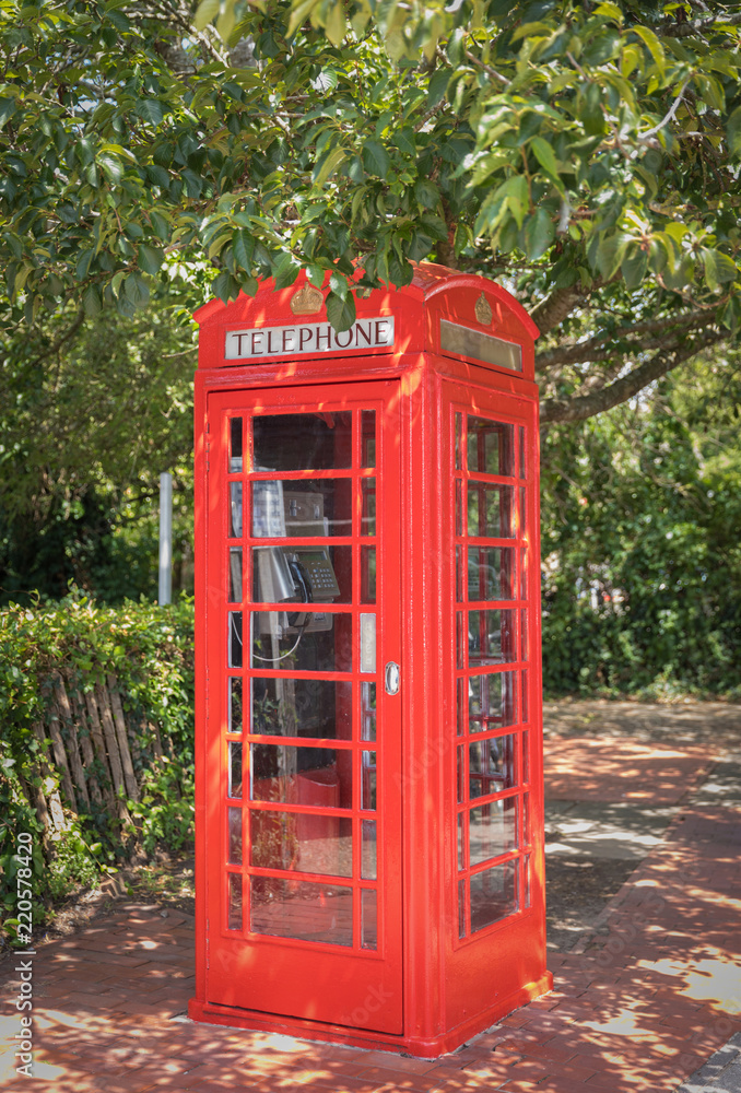 Classical red telephone booth in English trees Classical red telephone booth in English trees