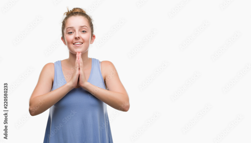 Young blonde woman praying with hands together asking for forgiveness smiling confident. Young blonde woman praying with hands together asking for forgiveness smiling confident.