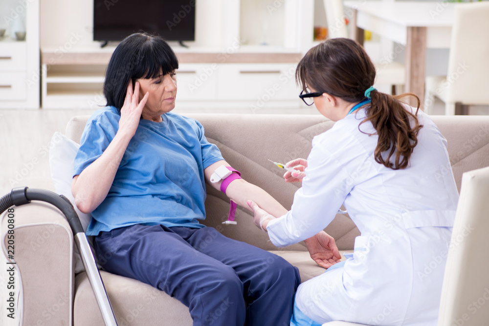 Obraz premium Doctor making injection to senior old woman