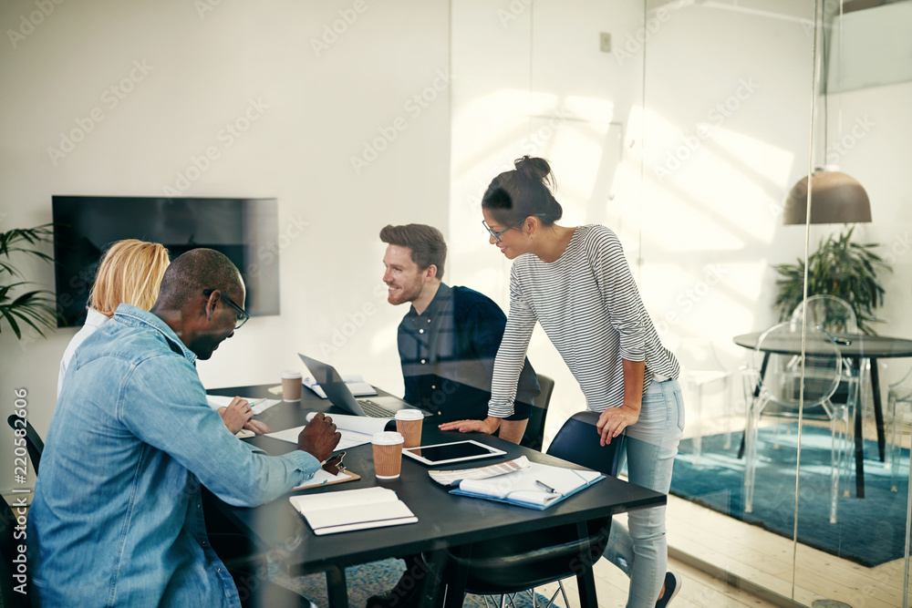 Diverse businesspeople smiling and talking together during a mee Diverse businesspeople smiling and talking together during a mee