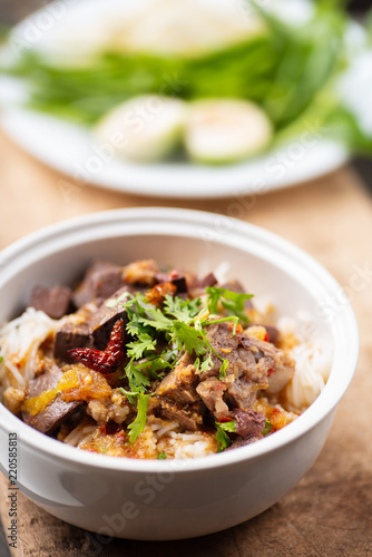 Northern Thai food (Kanom Jeen Nam Ngeaw) with vegetables on wooden background,spicy rice noodles soup