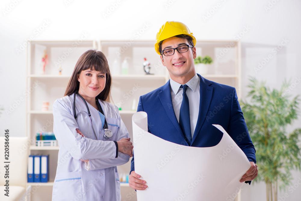 Doctor discussing new hospital plan with architect Doctor discussing new hospital plan with architect