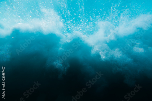 Wave in underwater. Wave crashing on beach, clouds of water