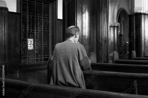 Back View Of An Old Man Praying In The Church