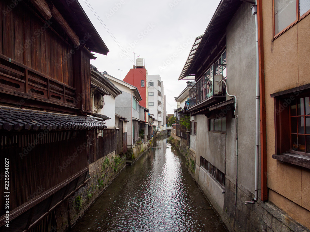 Wide detail of multiple concrete buildings and traditional wooden houses along the canals of Kurokabe residential district. Nagahama, Shiga, Japan. Travel and architecture