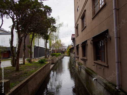 Wide detail of concrete buildings and trees along the canals near Kurokabe Square. Nagahama, Shiga, Japan. Travel and architecture. © substancep