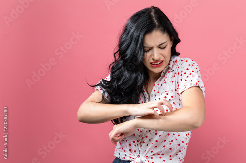 Young woman scratching her itchy arm. Skin problem. photo