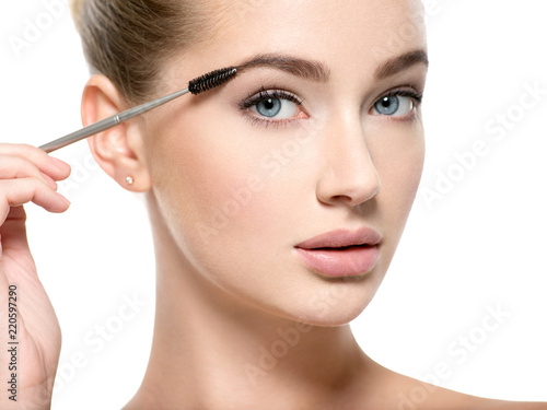 Girl makes makeup. Woman apply mascara on eyelashes