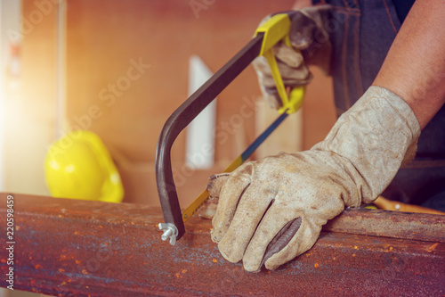 Schilderij op canvas Close up of Craftsman worker sawing a steel pipe, Technician concept