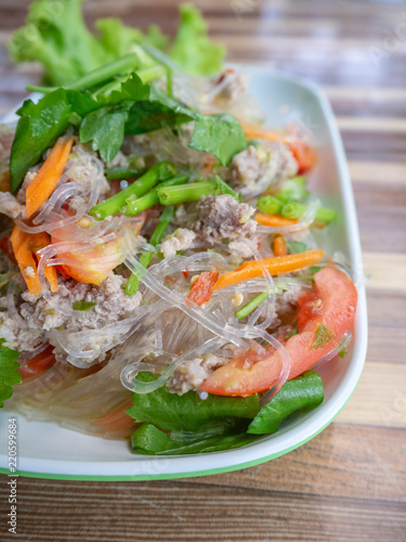 Thai spicy vermicelli salad with minced pork in a white plate