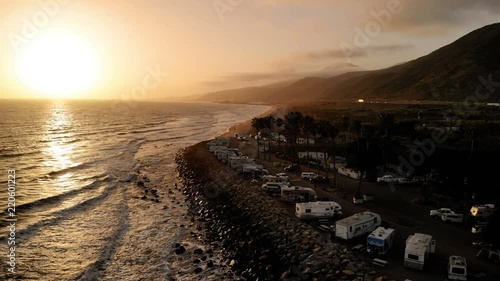 RV park (campground) at coast, California. Ocean. California during sunset. Aerial view, from above, drone flying over water.

