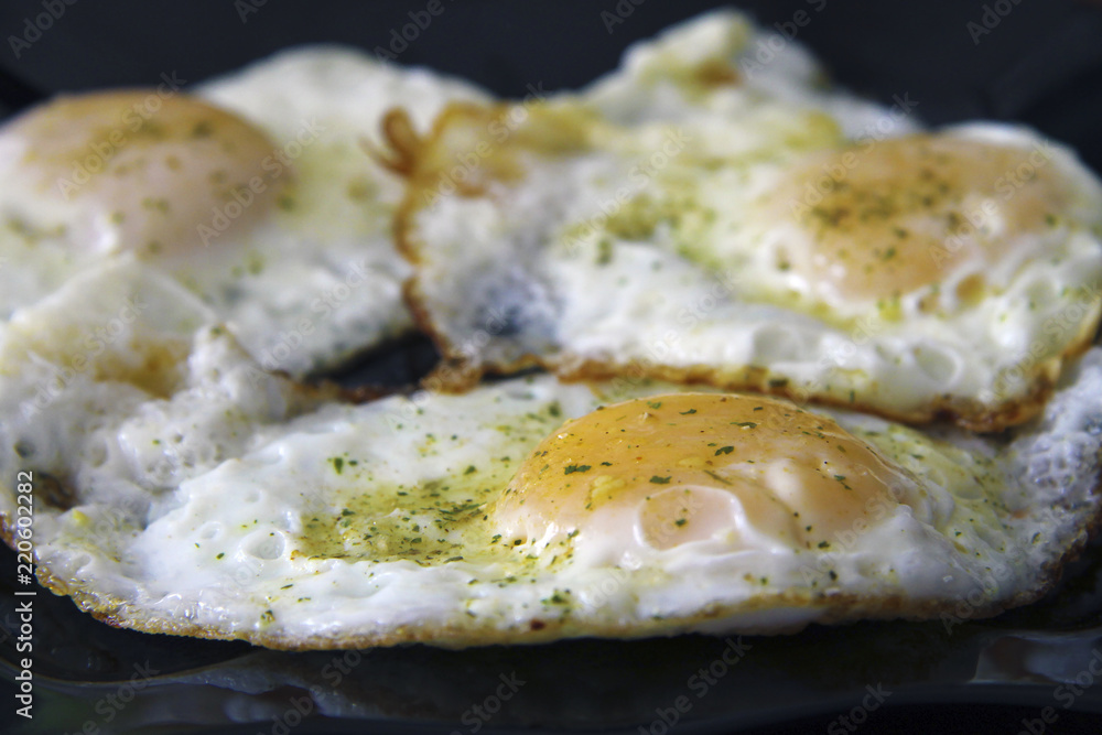 Roasted eggs on the black plate and dill over Roasted eggs on the black plate and dill over