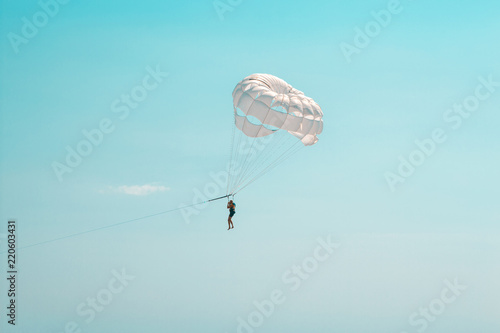 man flies on a white parachute