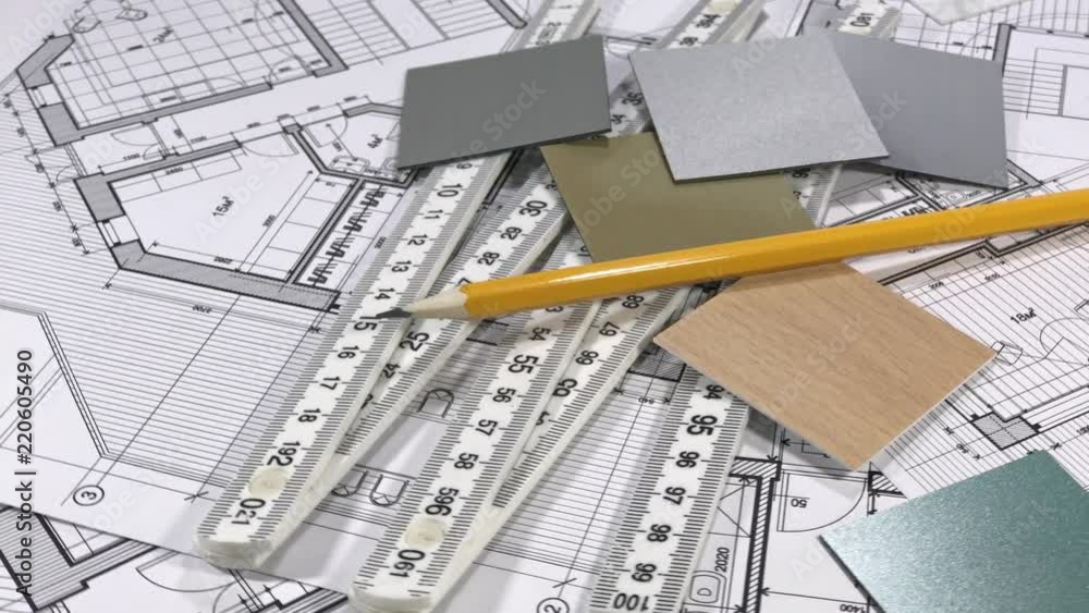 Blueprints: architectural drawings, yardstick - folding ruler & samples of modern interior decoration materials - decorative plastics smoothly rotate on the surface of the architectural plan Blueprints: architectural drawings, yardstick - folding ruler & samples of modern interior decoration materials - decorative plastics smoothly rotate on the surface of the architectural plan
