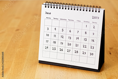 Month page: June in 2019 paper calendar with funny font on the wooden table photo