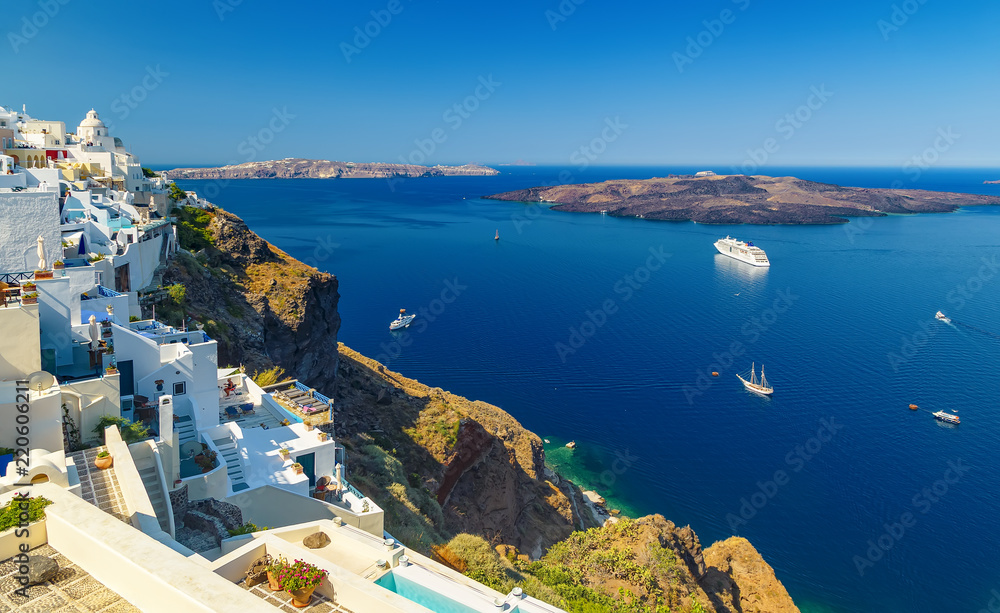 Oia town on Santorini island, Greece. Traditional and famous white houses and churches with blue domes over the Caldera, Aegean sea