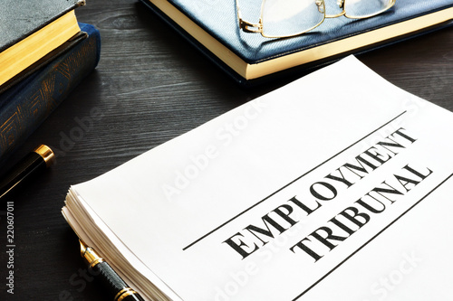 Employment tribunal documents, note pad and glasses.