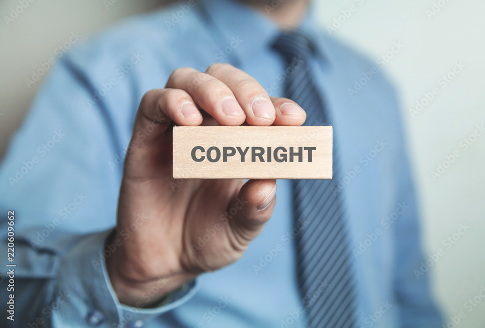 Businessman showing Copyright word in wooden block. Business concept Businessman showing Copyright word in wooden block. Business concept