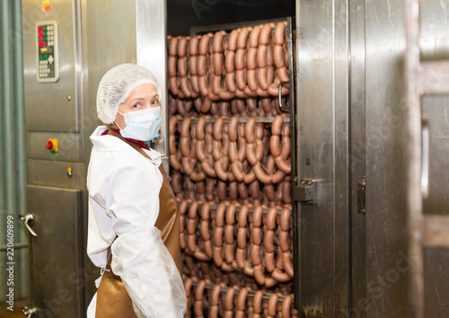 Female controlling hot processing of sausages