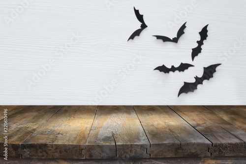 Wooden rustic table and Halloween bats on wall