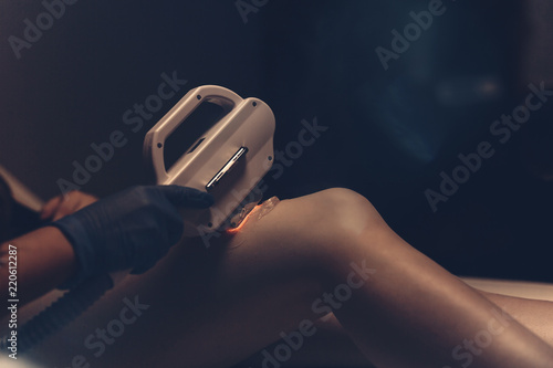 Intense pulsed light used in beauty shaving depilation with ipl epilator machine. Professional procedure for hair removal in clinic salon removing hair epilator device photo