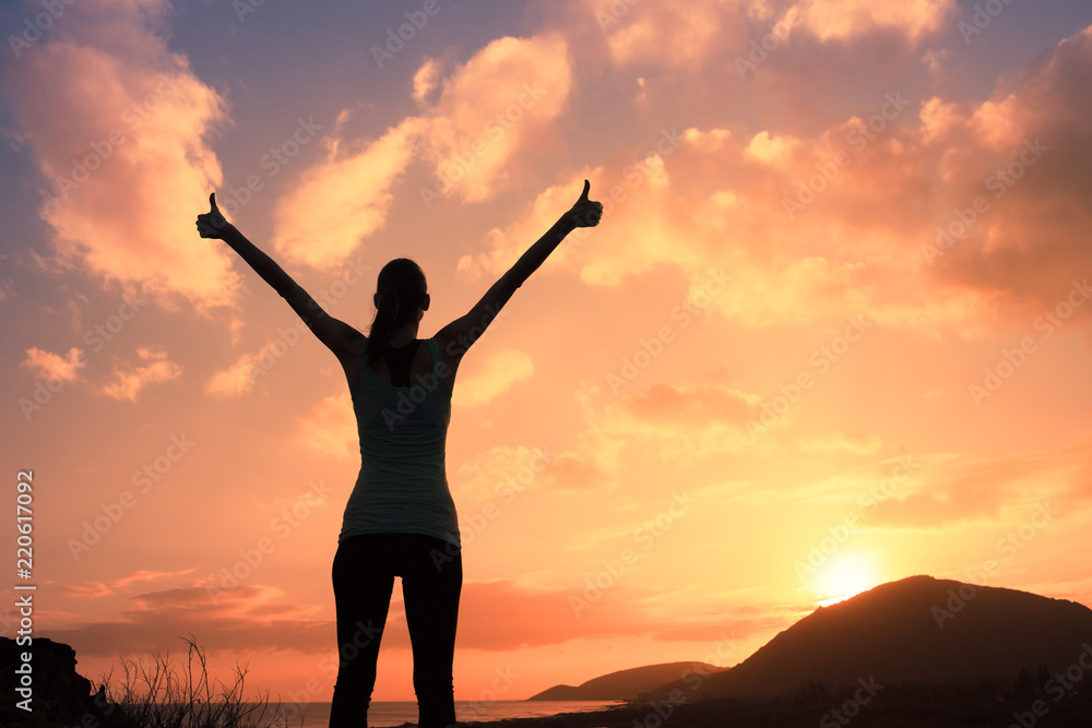 Winning, success , and life goals concept. Young woman with arms in the air giving thumbs up.
Winning, success , and life goals concept. Young woman with arms in the air giving thumbs up.
