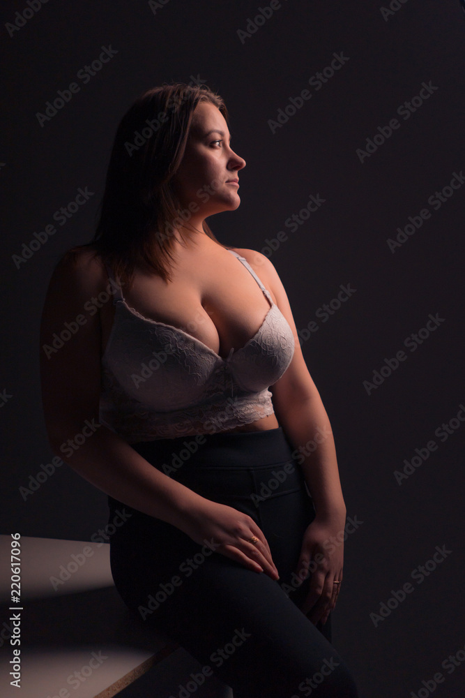 Plus size sexy model in white bra, fat woman with big natural breast on  gray studio background, overweight female body, long hair foto de Stock |  Adobe Stock