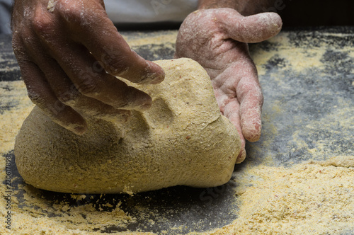 Male hands kneading dough on sprinkled