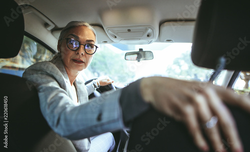 Senor woman driving a car in reverse