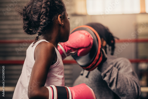 Rear view of a boxing kid practicing her punches