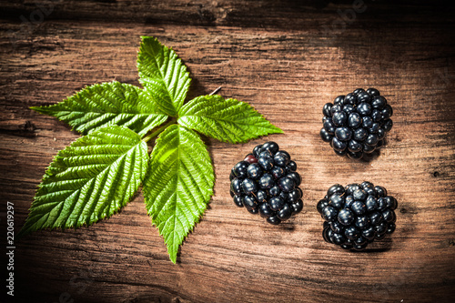 Sweet blackberries leaves on vintage wooden board