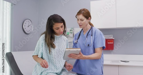 Middle aged medical nurse asking patient questions about general health